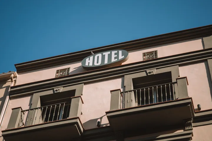 Façade d'un hôtel avec enseigne « HOTEL » et balcons en fer forgé